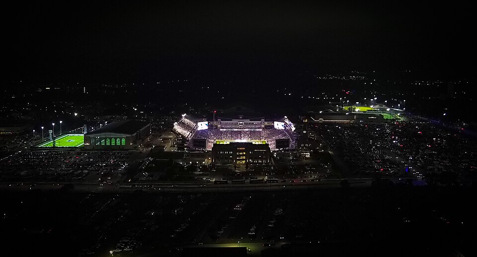 Vista aérea del estadio iluminado durante un partido nocturno de fútbol